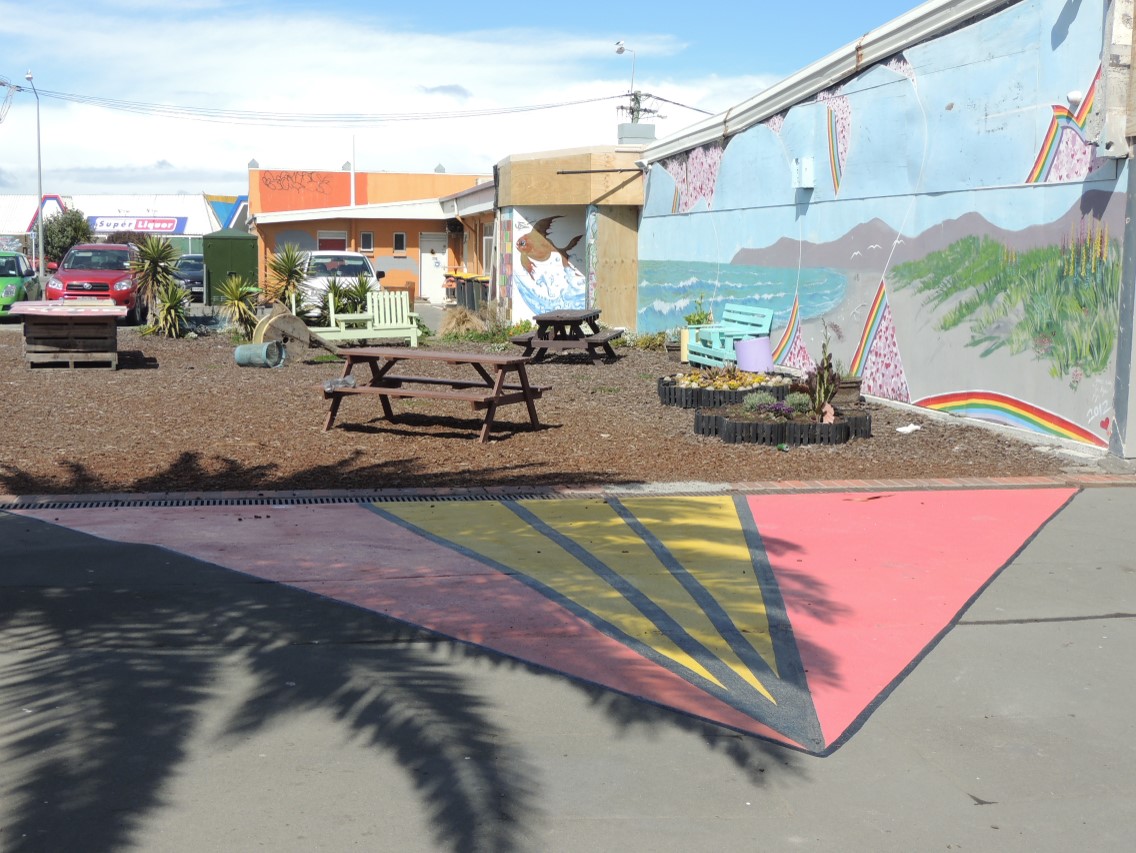 A pocket park with picnic tables and footpath painting