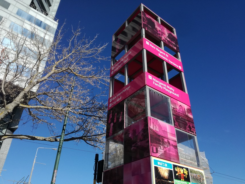 A tall pink tower displays directions to attractions