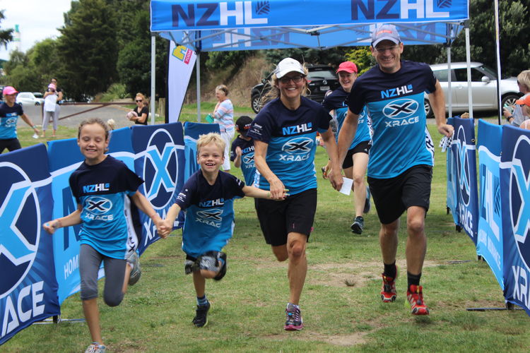 A family of four crossing the finish line at a  previous XRace event.